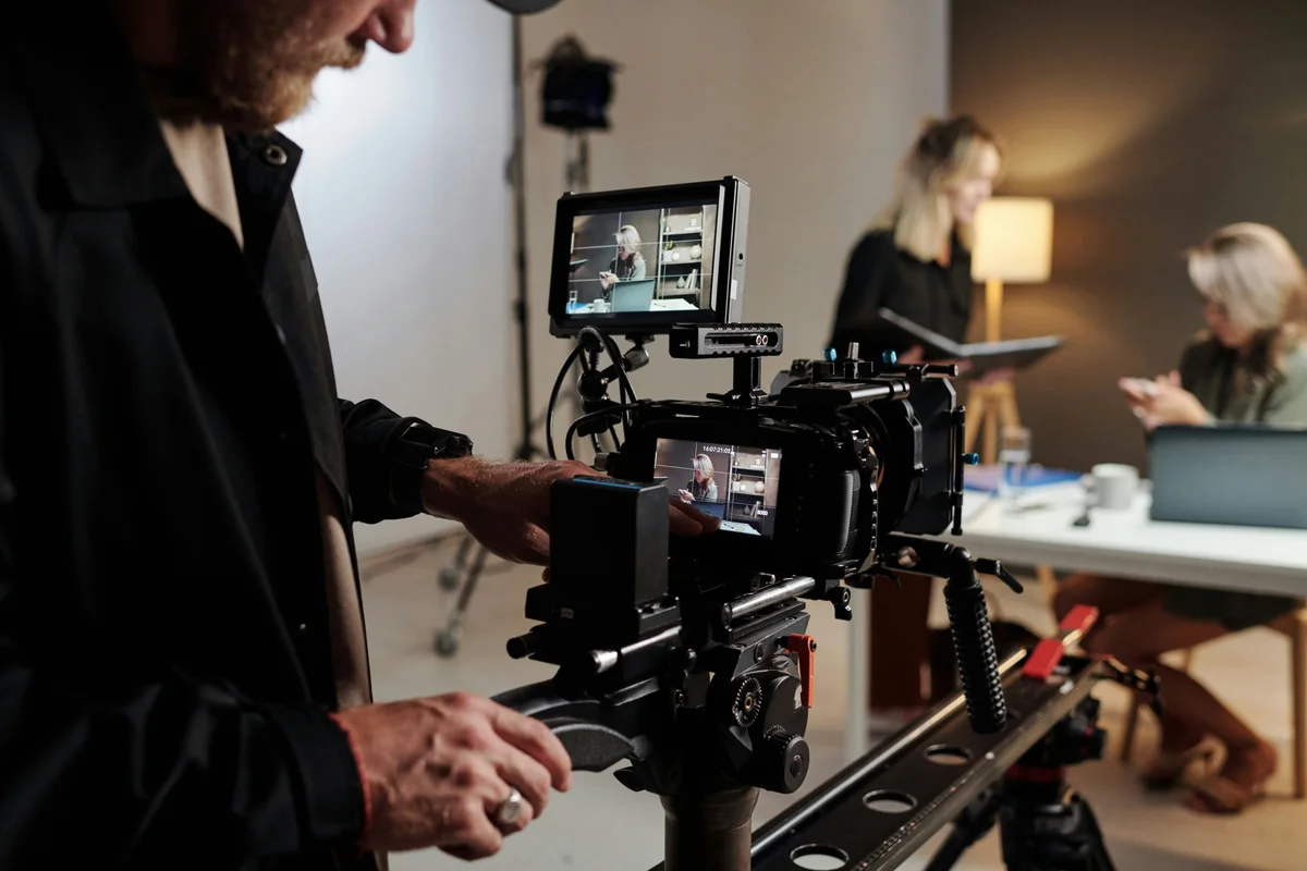 Camera operator filming an interview in a studio