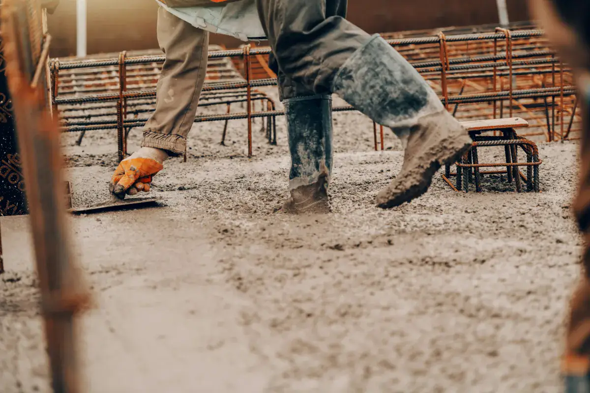 Tradesperson smoothing wet concrete on a job site